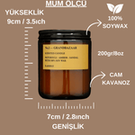 Dekoratif amber cam mum, odunsu ve baharatlı notalar içerir.